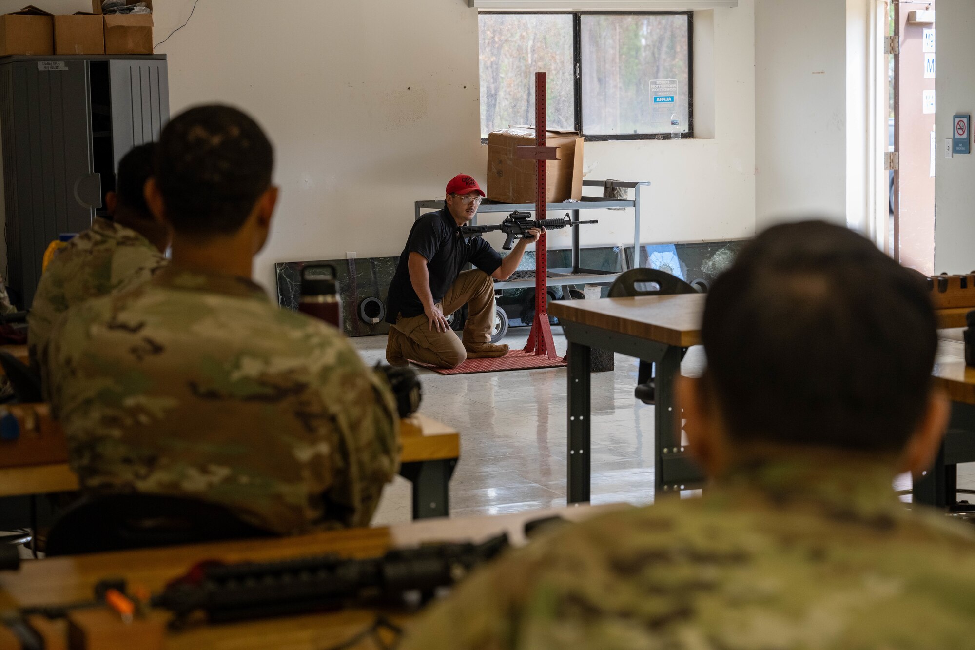 A U.S. Air Force combat arms training and maintenance instructor teaches Airmen different firing positions during CATM.
