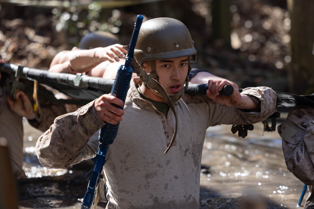 U.S. Navy Hospital Corpsman Dan Fiola, a student with Field Medical Training Battalion – East, and a native of Crescent City, California, carries a simulated casualty on a litter while maneuvering through an obstacle course at Camp Gilbert H. Johnson, North Carolina, March 3, 2025. Sailors with FMTB-E trained to conduct medical evacuations in permissive and non-permissive environments. (U.S. Marine Corps photo by Lance Cpl. Channah Chilton)