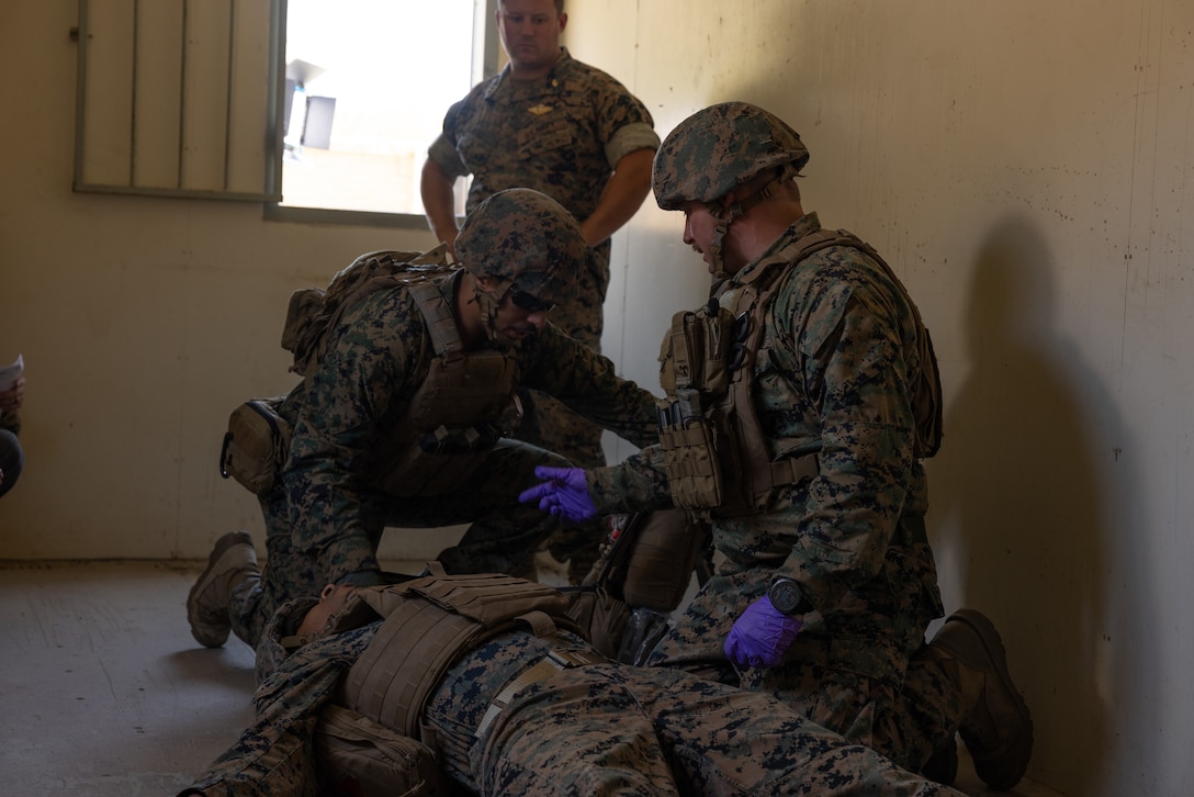 U.S. Marine Corps Sgt. Joe Malavez, left, a native of Worcester, Massachusetts, and U.S. Navy Petty Officer 1st Class, right, a native of Baytown, Texas, both instructors with Field Medical Training Battalion – West, simulate giving medical care under fire during the filming of an instructional media production at Camp Pendleton, California, July 23, 2024. U.S. Marines and U.S. Navy Sailors with FMTB-W demonstrated techniques to educate sailors on how to render medical aid under combat conditions. (U.S. Marine Corps photo by Lance Cpl. James Bricker)