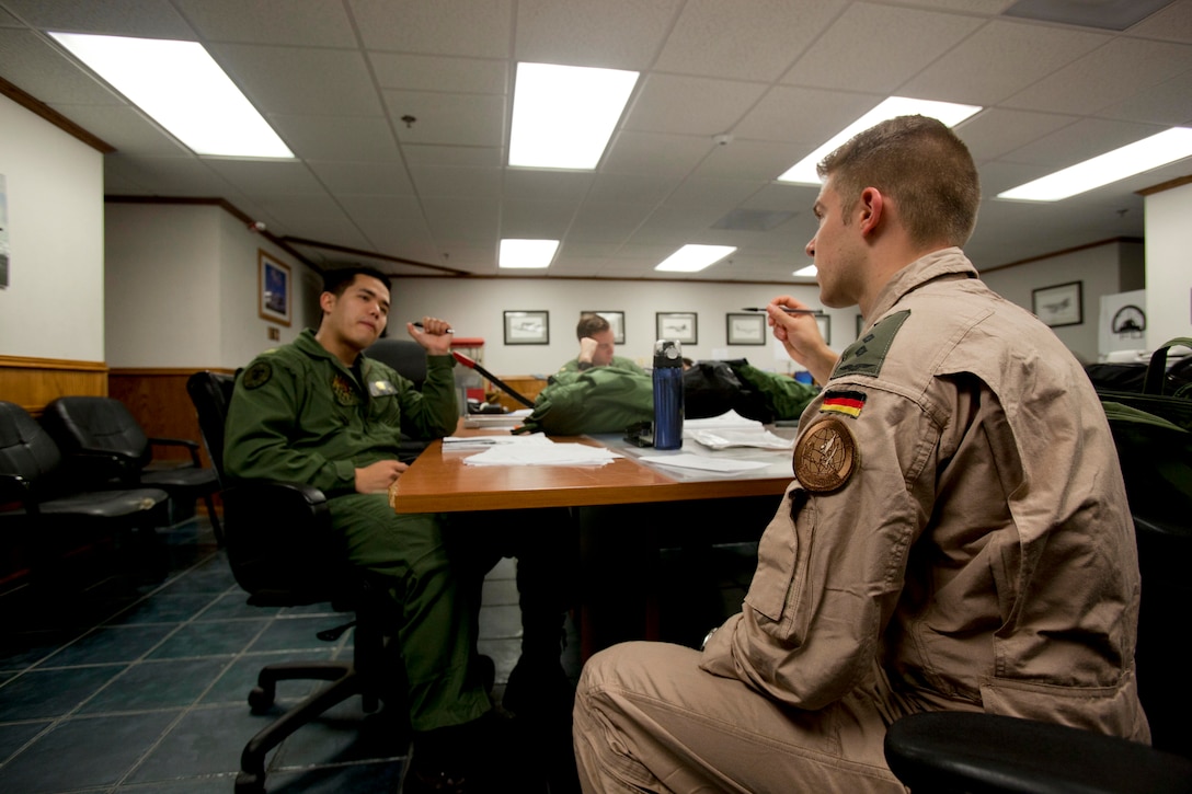German Luftwaffe (Air Force) 1st Lt.Christian K. Trenk, right, a student with Marine Aviation Training Support Group (MATSG) 21, discusses pre-flight plans with U.S. Navy Ensign Brandon L. Tean at Naval Air Station Pensacola, Fla., April 19, 2016. MATSG-21 is a formal school dedicated to training students to become naval flight officers. (U.S. Marine Corps photo by Lance Cpl. Jose Villalobosrocha/ Released)