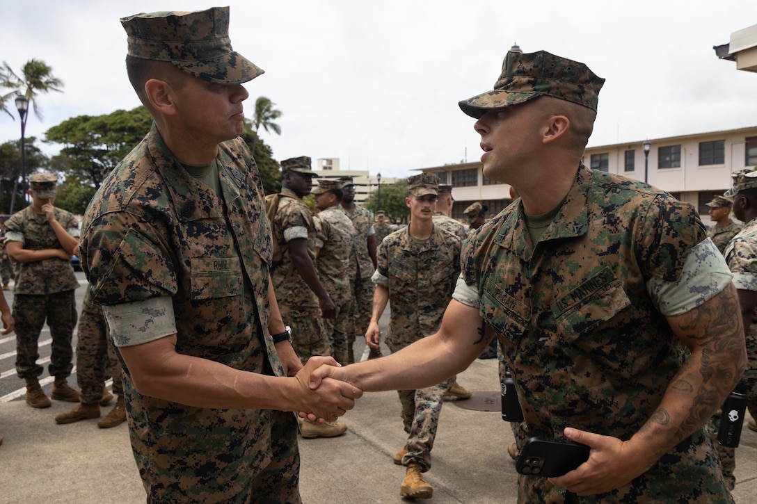 U.S. Marine Corps Sgt. Maj. Carlos A. Ruiz, the 20th Sergeant Major of the Marine Corps, left, engages with Marines following a town hall at Marine Corps Base Hawaii (MCBH), June 24, 2025. During his visit, Ruiz met with leadership from MCBH, visited the College of Enlisted Military Education - Staff Noncommissioned Officer Academy, conducted a barracks walkthrough, toured the MCBH Individual Issue Facility (IIF), and spoke at an all-hands town hall. Ruiz visited MCBH to gain a better understanding of current operations. (U.S. Marine Corps photo by Lance Cpl. Tania Guerrero)