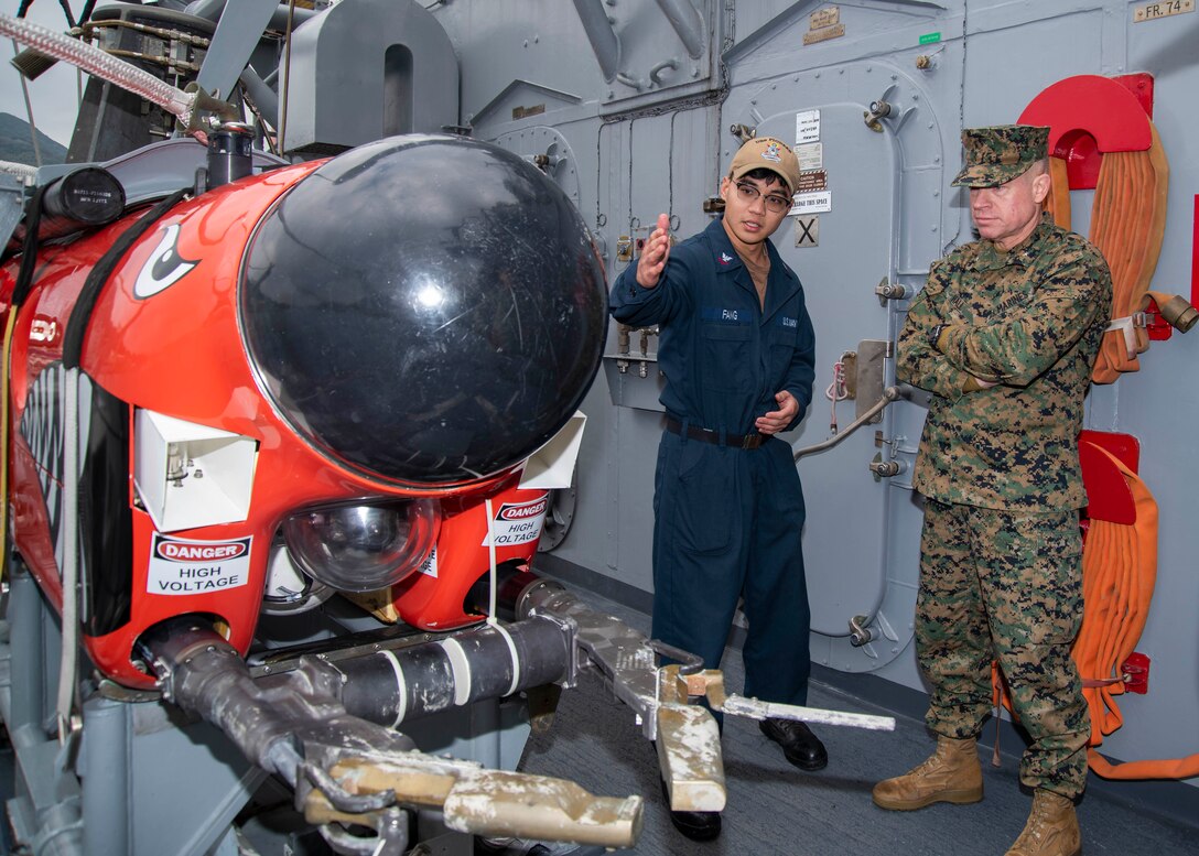 SASEBO, Japan (Feb. 9, 2024) — Mineman 2nd Class William Fang, from Brooklyn, New York and assigned to the Avenger-Class mine countermeasures ship USS Pioneer (MCM 9), speaks to Brig. Gen. Trevor Hall, Commanding General, 3rd Marine Expeditionary Brigade and deputy commander of Task Force 76/3, about the ship’s mine countermeasure capabilities in Sasebo, Japan Feb. 9, 2024. Task Force 76/3 is an operational command based out of Okinawa and is responsible for conducting expeditionary warfare operations to support a full range of U.S. Seventh Fleet theater contingencies, ranging from humanitarian assistance and disaster relief to full combat operations. (U.S. Navy photo by Mass Communication Specialist Second Class Chase Stephens/Released)