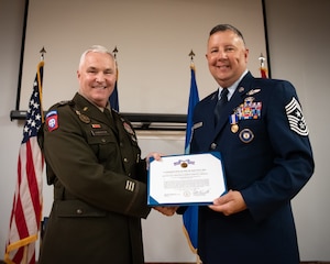 Chief Master Sgt. James Tongate, right, Kentucky Air National Guard state command chief, is presented with the Kentucky Distinguished Service Medal by U.S. Army Maj. Gen. Haldane Lamberton, Kentucky’s adjutant general, during Tongate’s retirement ceremony at the Kentucky Air National Guard Base in Louisville, Ky., April 13, 2025. Tongate served the U.S. military for 33 years. (U.S. Air National Guard photo by Master Sgt. Joshua Horton)