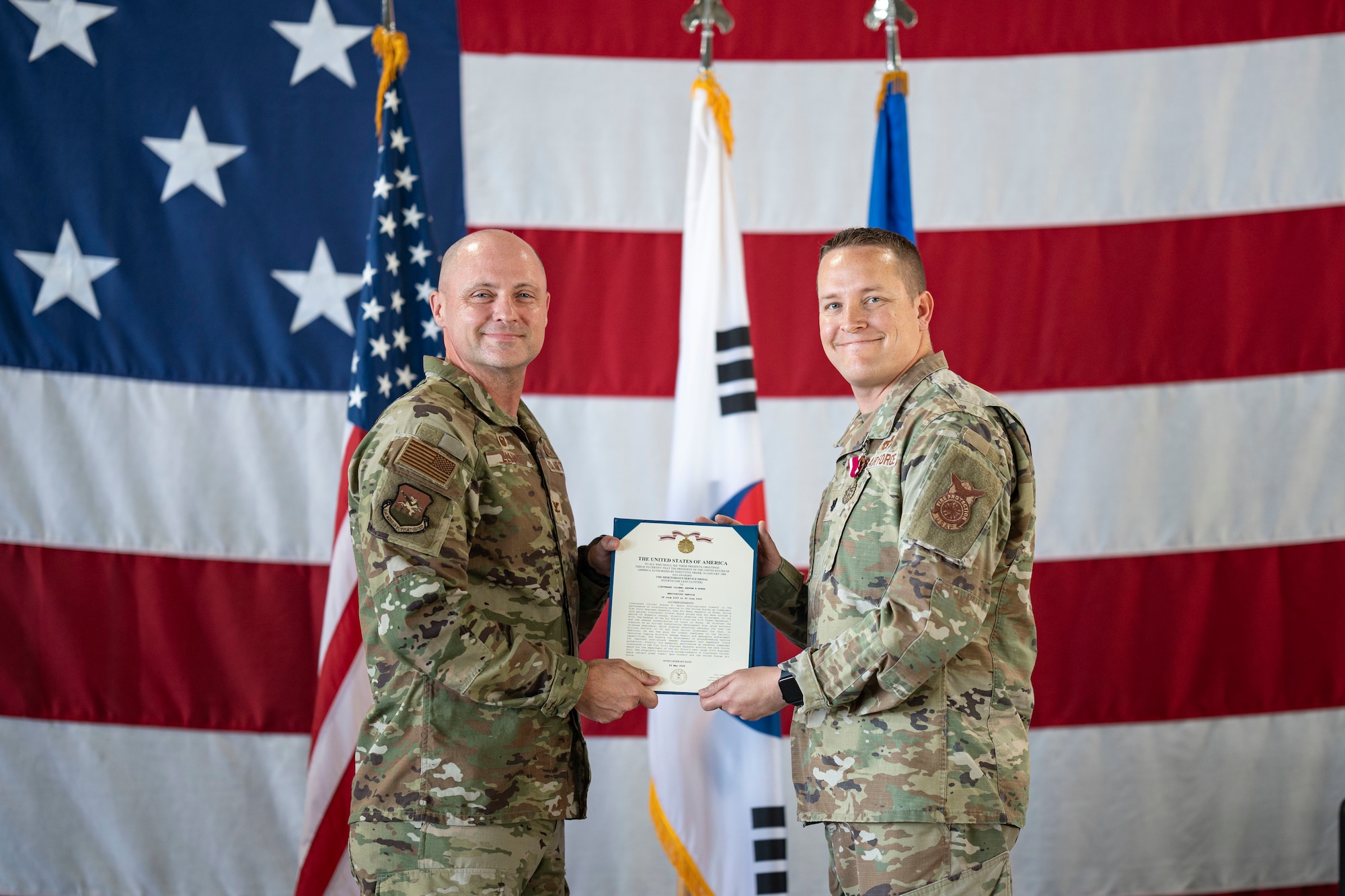 U.S. Air Force Lt. Col. Andrew Myers, right, outgoing 51st Civil Engineering Squadron, right, receives the Meritorious Service Medal from Col. Jeff Elliott, left, 51st Civil Engineering Group commander, during a Change of Command ceremony at Osan Air Base, Republic of Korea, June 30, 2025.