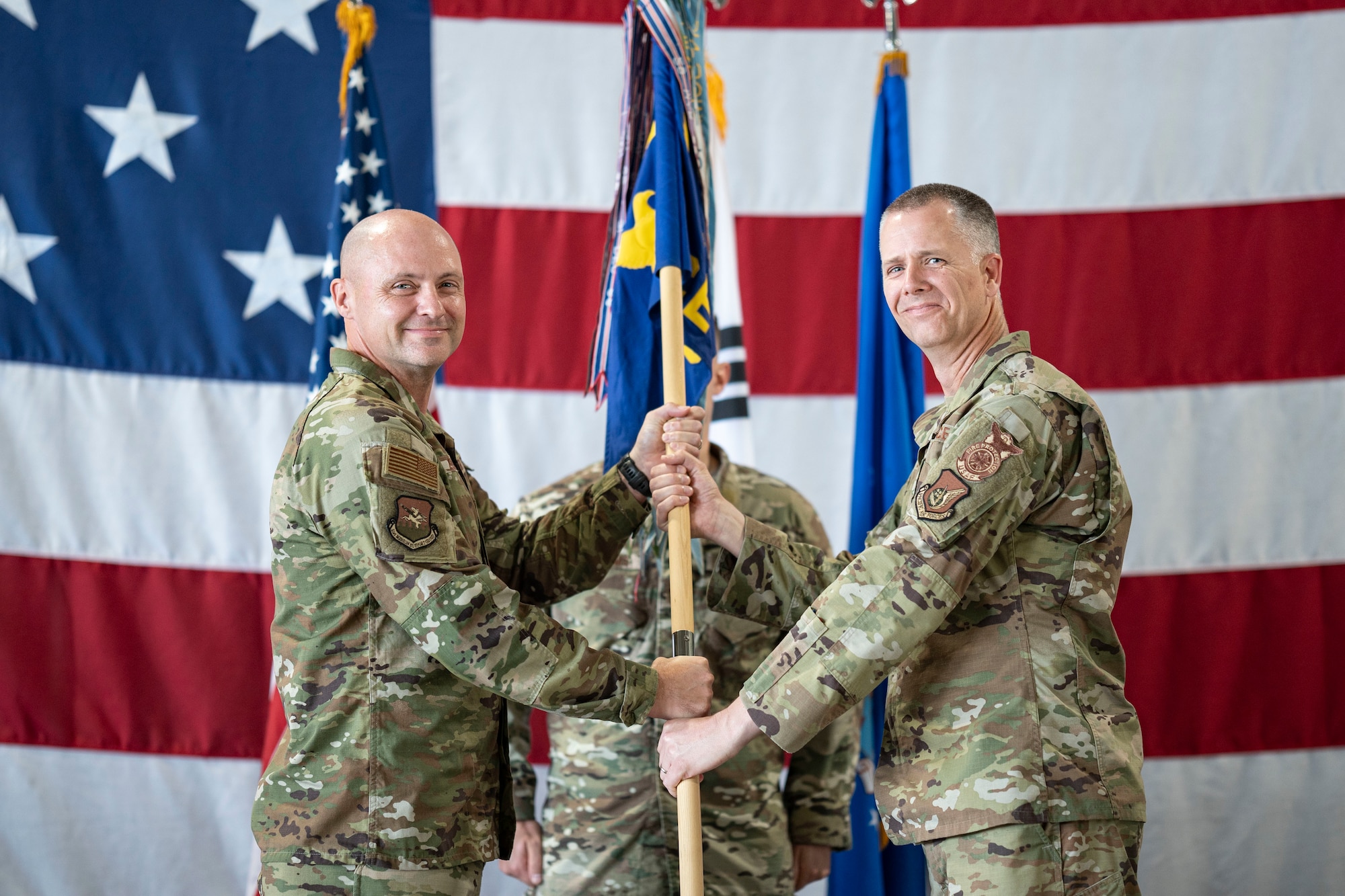 U.S. Air Force Col. Jeff Elliott, left, 51st Civil Engineering Group commander, passes  the guidon to Lt. Col. Kirk Hull, incoming 51st Civil Engineer Squadron commander, during a Change of Command ceremony at Osan Air Base, Republic of Korea, June 30, 2025.
