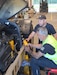 Michael Drutti, the automotive maintenance supervisor at the Zutendaal Army Prepositioned Stocks-2 worksite, watches a mechanic on his team install a new fuel filter on a Light Capability Rough Terrain Forklift at the Zutendaal APS-2 worksite, June 30, 2025. (U.S. Army courtesy photo)