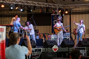 Members of American Authors thank U.S. Air Force Col. Albert Esposito, 39th Air Base Wing commander, after he joined them onstage for a surprise performance during the Heat Wave Concert Series at Incirlik Air Base, Türkiye, June 28, 2025.