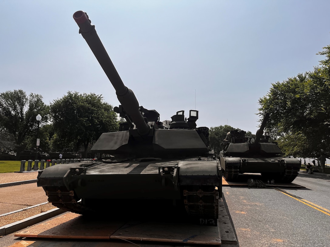 A tank sits on top of a steel plate in the middle of a roadway.
