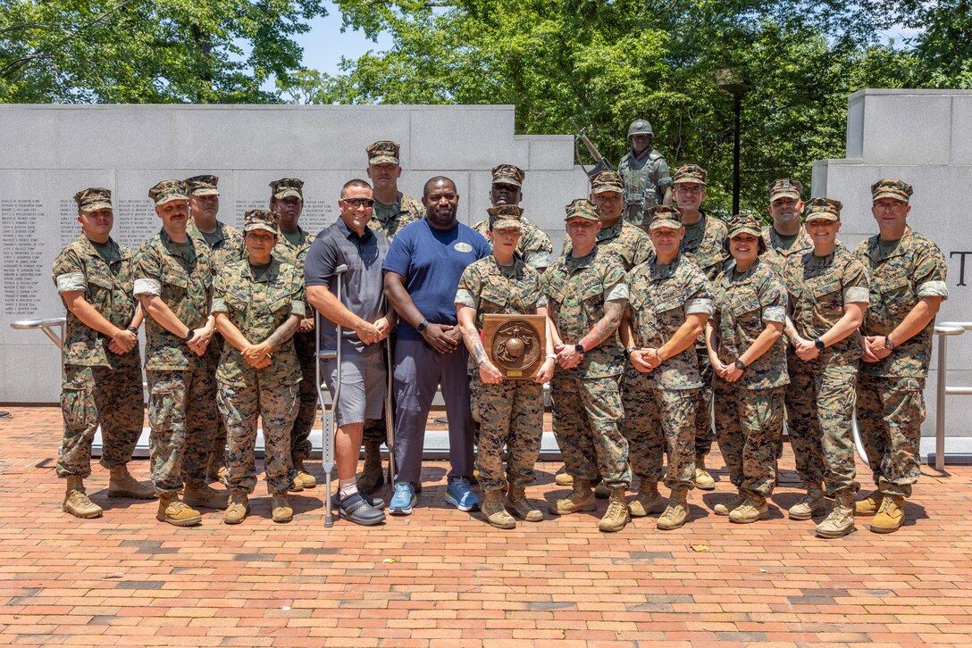 U.S. Navy Hospital Corpsman 1st Class Stacie Marturano, center holding award, assigned to 24th Marine Expeditionary Unit, II Marine Expeditionary Force, poses for a photo with fellow Sailors after an award ceremony at the Beirut Memorial in Jacksonville, North Carolina, June 26, 2025. Marturano was the recipient of the Marine Corps League's Chief Hospital Corpsman George William “Doc” Piercy Award, an award presented to a Navy corpsman in the operating forces who has made a significant contribution to increase combat medical readiness within the organization. Marturano, a corpsman with 2nd Medical Battalion, 2nd Marine Logistics Group, was assigned to support the 24th MEU, where she played a critical role in achieving 100% deployment readiness for over 2,000 Marines and Sailors in a high operationally demanding command. (U.S. Marine Corps photo by Cpl. Christian Salazar)
