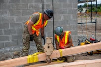 U.S. Army Staff Sgt. Zachary Williamson, left, and Spc. Pharez Telona, with the 176th Engineer Company, 420th Chemical Battalion, 96th Troop Command, Washington National Guard, prepares the beam for installation on the roof of a restroom facility at Charter Park, Orting, Wash, June 19, 2025.