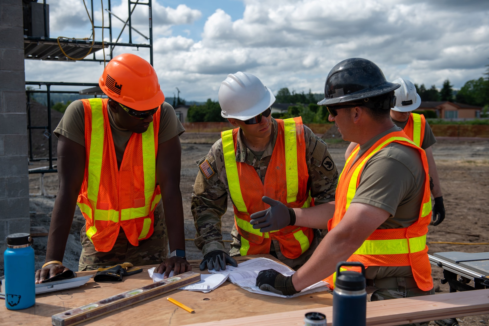 U.S. Army Staff Sgt. Zachary Williamson, right, with the 176th Engineer Company, 420th Chemical Battalion, 96th Troop Command, Washington National Guard, is instructing Soldiers in his unit about tongue and groove roof decking for the restroom facility at Charter Park, Orting, Wash, June 19, 2025.