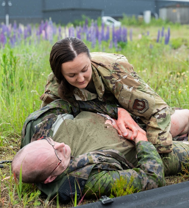 U.S. Air Force Capt. Samantha Holmquist, 86th Aerospace Medical Evacuation Squadron flight nurse, assists a Finnish Air Force member acting as a mass casualty victim during exercise Atlantic Trident 25 at Halli Air Base, Finland, June 18, 2025. AT 25 is a large-scale training exercise, spanning across five Finnish Air Force bases, allowing participating Allies to demonstrate different readiness and response tactics in joint-learning environments. (U.S. Air Force photo by Airman 1st Class Sierra Casteel)