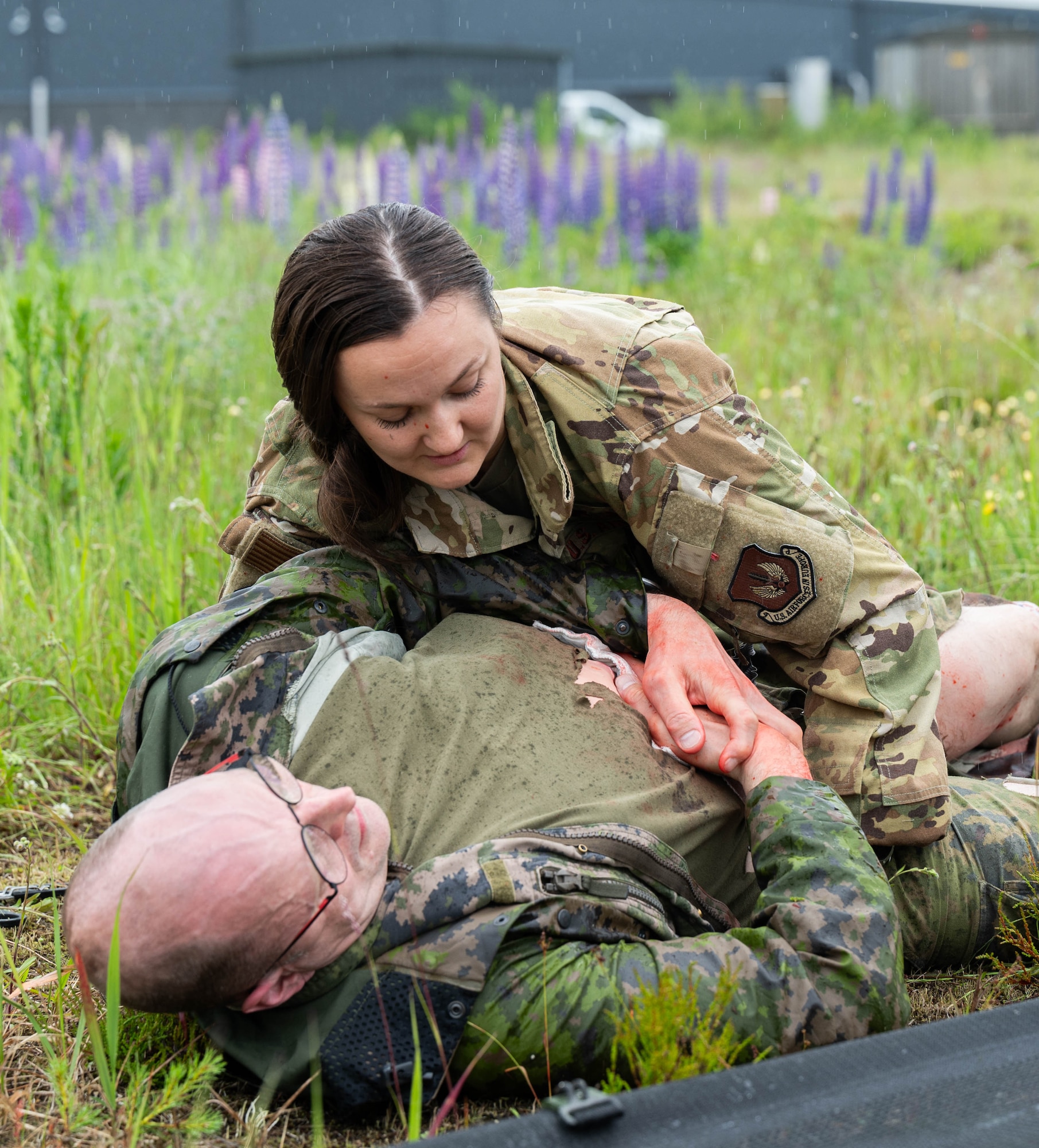 U.S. Air Force Capt. Samantha Holmquist, 86th Aerospace Medical Evacuation Squadron flight nurse, assists a Finnish Air Force member acting as a mass casualty victim during exercise Atlantic Trident 25 at Halli Air Base, Finland, June 18, 2025. AT 25 is a large-scale training exercise, spanning across five Finnish Air Force bases, allowing participating Allies to demonstrate different readiness and response tactics in joint-learning environments. (U.S. Air Force photo by Airman 1st Class Sierra Casteel)