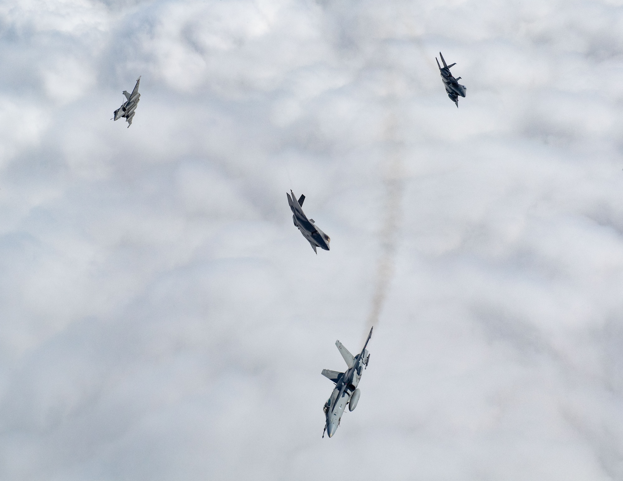 A U.S. F-15E Strike Eagle, U.S. F-35A Lightning II, Finnish F/A-18 Hornet, and French Rafale break away from a formation during exercise Atlantic Trident 25 over Finland, June 20, 2025. Atlantic Trident 25 builds military capability and warfighting capacity between the U.S., U.K., France and Finland to support deterrence and defense of the Euro-Atlantic region, ensuring continued readiness, adaptability and lethality. (U.S. Air National Guard photo by Airman 1st Class Bridget Rossignol)