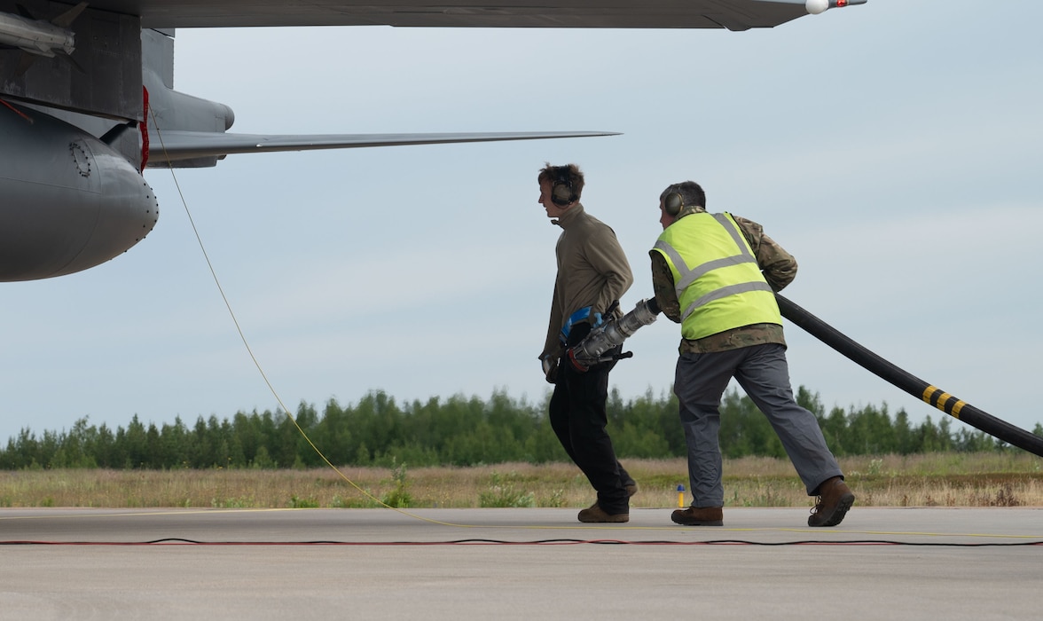 A U.S. Airman prepares to refuel a U.S. Air Force F-15E Strike Eagle during hot pit refueling with a Royal Air Force member at exercise Atlantic Trident 25 at Halli Air Base, Finland, June 23, 2025. Recurring training events like Atlantic Trident allow the U.S. to forward deploy combat power, train in complex air environments and sharpen integration with close partners. (U.S. Air Force photo by Senior Airman AshleyTalley)