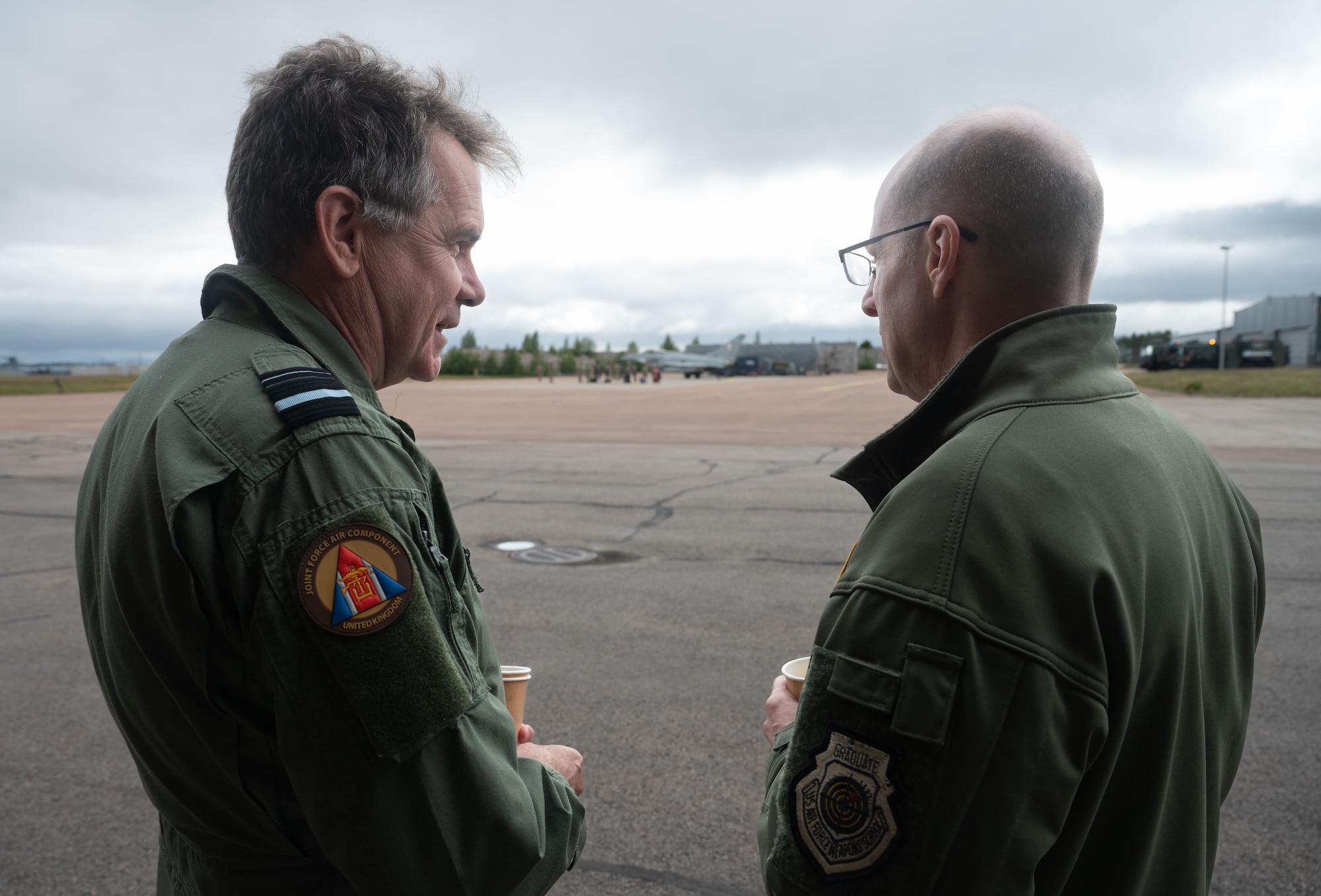 Royal Air Force Air Vice Marshall Tom Burke, left, Air Officer Commanding 11 Group, and U.S. Air Force Lt. Gen. Jason Hinds, U.S. Air Forces in Europe - Air Forces Africa deputy commander, observe a hot pit refueling demonstration during exercise Atlantic Trident 25 at Halli Air Base, Finland, June 26, 2025. The U.S., U.K., and Finnish forces conducted hot pit refueling utilizing advanced training opportunities with fourth- and fifth-generation aircraft to collaborate and operate in a high-intensity, interoperable environment. (U.S. Air Force photo by Senior Airman Ashley Talley)