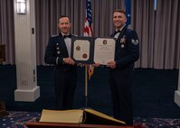 photo of two Air Force Honor Guard members holding a certificate.