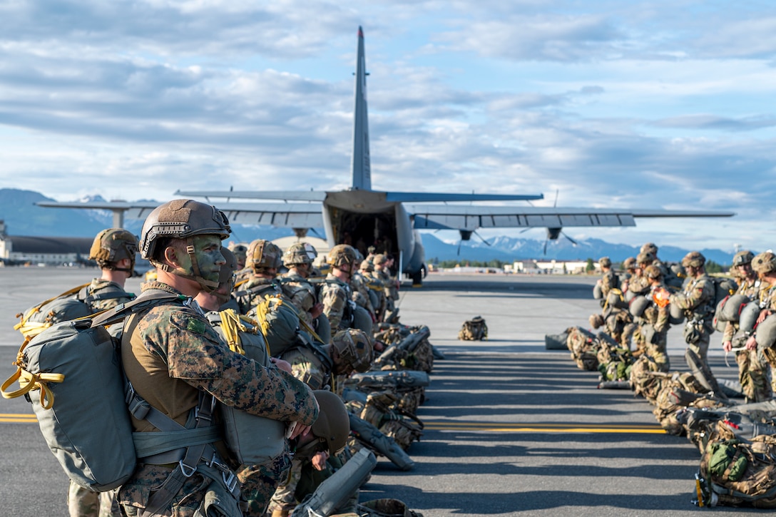 U.S. Army Soldiers assigned to the 11th Airborne Division and U.S. Marine Corps Marines assigned to the 4th Air Naval Gunfire Liaison Company wait to board a C-130 Hercules for a static line jump during Red Flag-Alaska 25-2 at Joint Base Elmendorf-Richardson, Alaska, June 18, 2025. This exercise simulates the complexities of potential Indo-Pacific scenarios, providing unique opportunities to integrate various forces into joint, coalition and multilateral training from simulated forward operating bases, enhancing the U.S. and allies’ ability to respond effectively to contingencies in the region. (U.S. Air Force photo by Senior Airman Matthew Arachikavitz)
