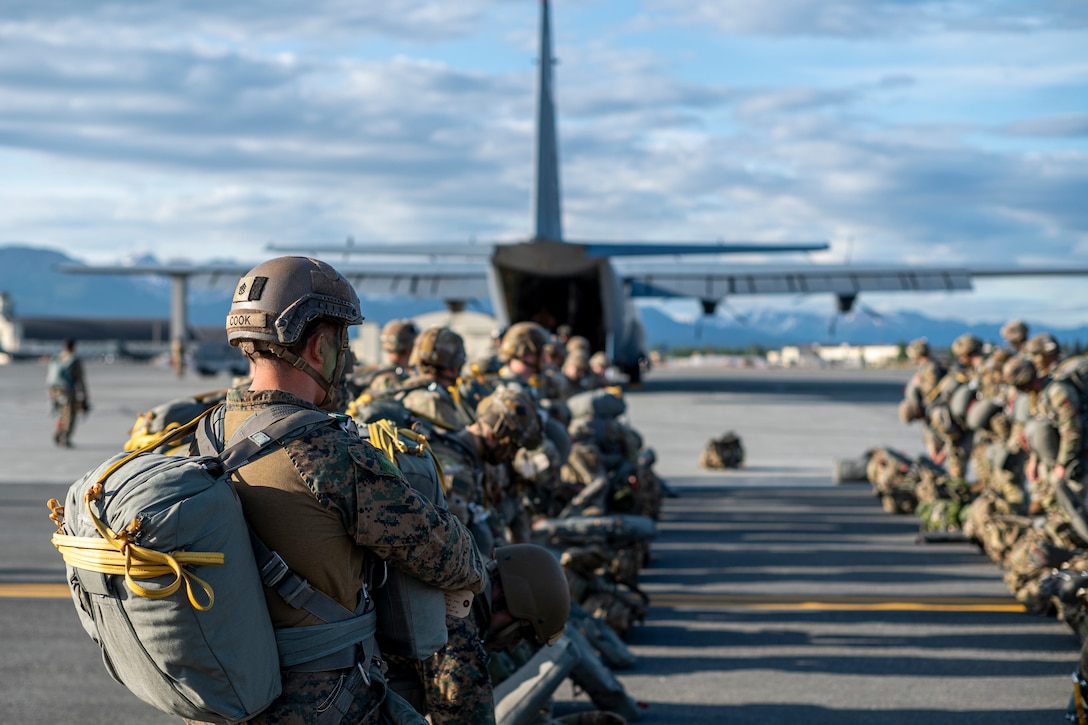 U.S. Army Soldiers assigned to the 11th Airborne Division and U.S. Marine Corps Marines assigned to the 4th Air Naval Gunfire Liaison Company wait to board a C-130 Hercules for a static line jump during Red Flag-Alaska 25-2 at Joint Base Elmendorf-Richardson, Alaska, June 18, 2025. This exercise simulates the complexities of potential Indo-Pacific scenarios, providing unique opportunities to integrate various forces into joint, coalition and multilateral training from simulated forward operating bases, enhancing the U.S. and allies’ ability to respond effectively to contingencies in the region. (U.S. Air Force photo by Senior Airman Matthew Arachikavitz)
