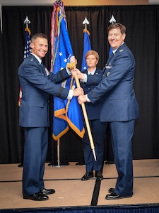 Two Air Force members hold a guidon for the 363d Intelligence, Surveillance, and Reconnaissance Wing.