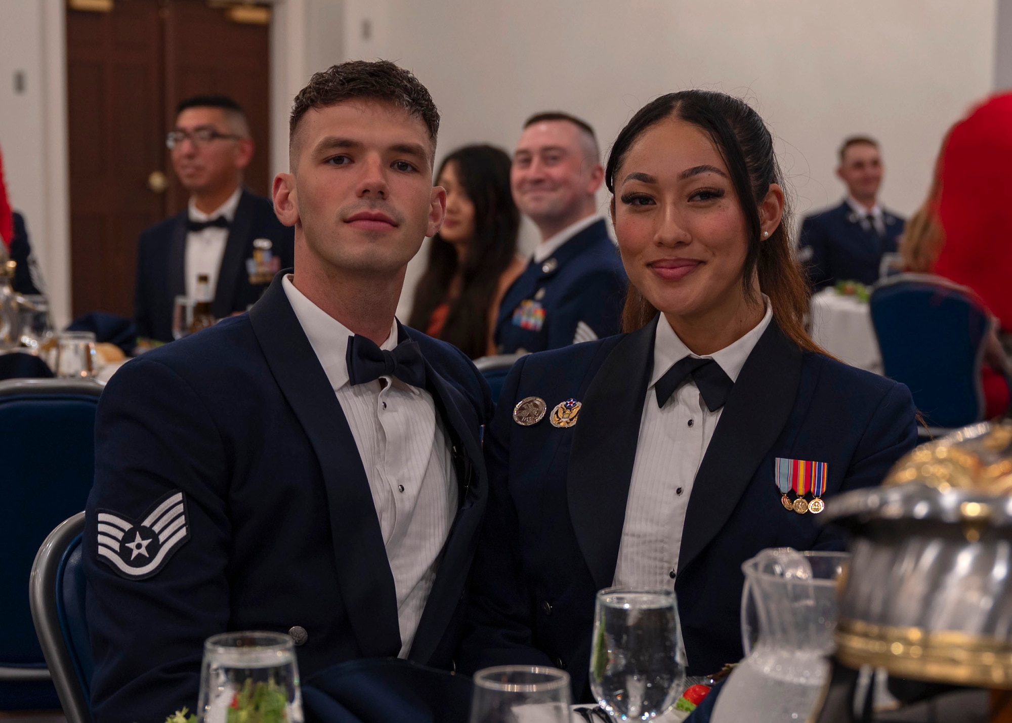 photo of two Air Force Honor Guard members sitting by a table during a formal ceremony