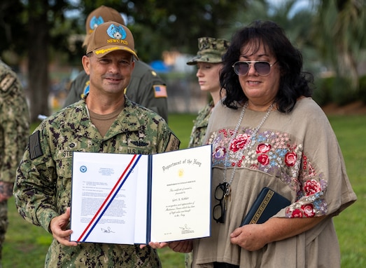 Naval Surface Warfare Center Panama City Division Commanding Officer Capt. Paul Stence, Jr., awards Geri Kohler, NSWC PCD military liaison, with the Department of the Navy Meritorious Civilian Service Award, June 13. Kohler manages all active-duty personnel and their administrative functions warfighters to seamlessly mesh and support the mission here while ensuring their operational readiness. (U.S. Navy photo by Bob Lindee)