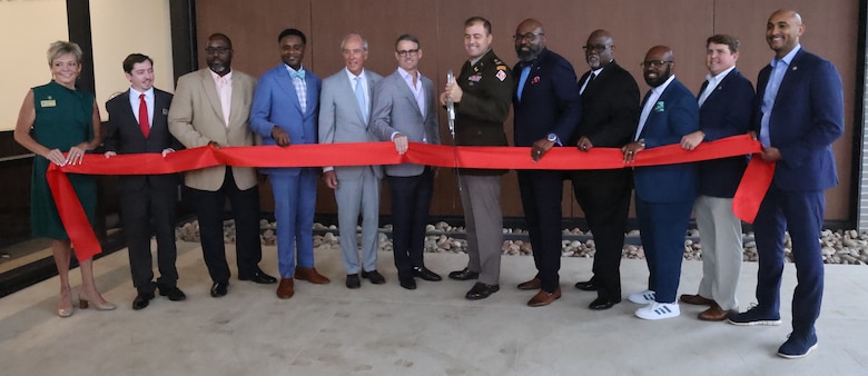 Picture of several people doing a ribbon cutting.