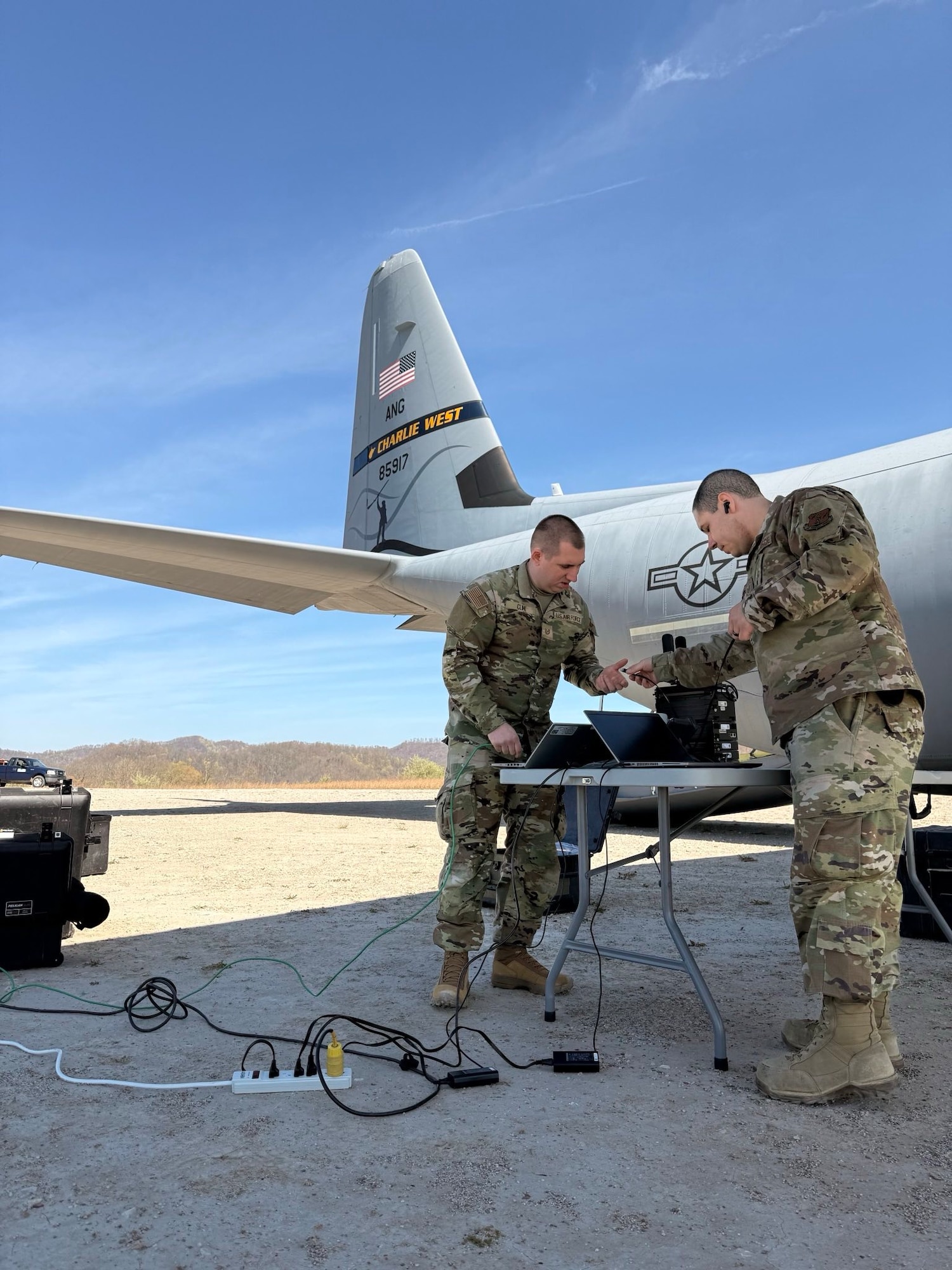 Airmen from the 130th Airlift Wing set up communications and support equipment under the wing of a C-130J Super Hercules during phase one of the Remote Integrated C-130J Omnidomain Operations Program (RICO-OP) at an austere landing strip in Logan County, W.Va., in early 2025. The exercise tested Agile Combat Employment and Mission Ready Airman capabilities in remote environments. (Courtesy photo)