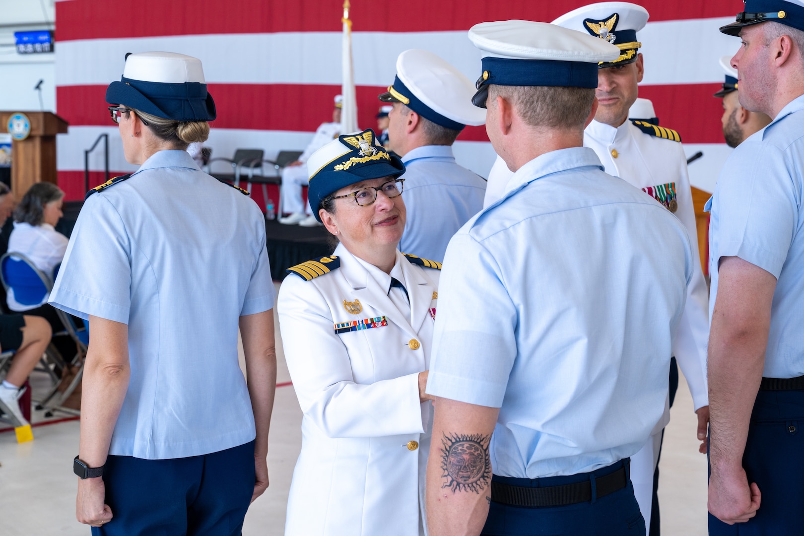 U.S. Coast Guard member inspects another member in formation.