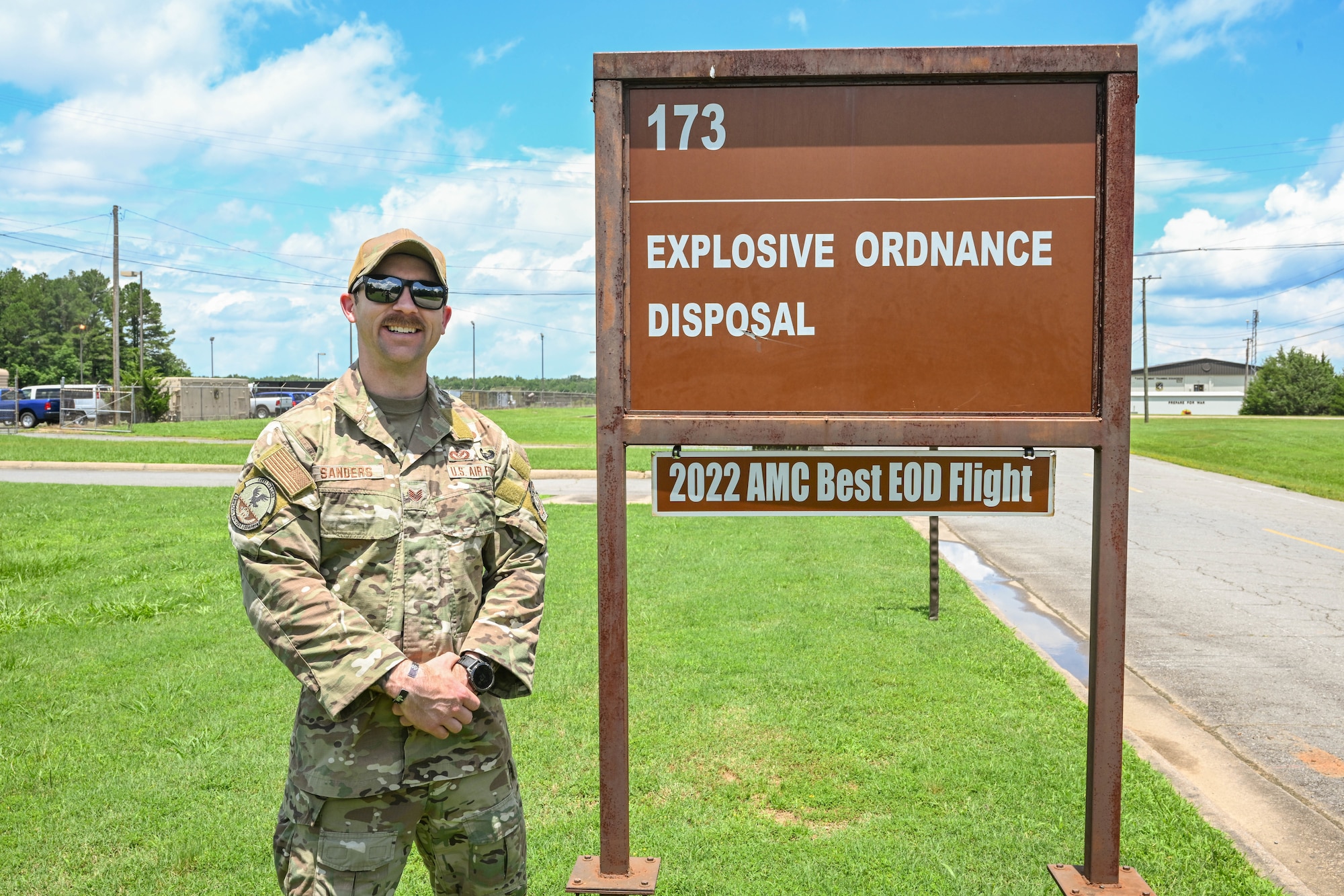 A man in uniform stands next to a sign.