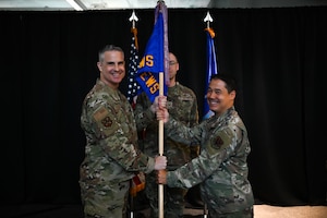 U.S. Air Force Col. Andrew Finkler, 850th Spectrum Warfare Group commander, left, passes the guidon to U.S. Air Force Lt. Col. Adrian De Freitas, 563d Electronic Warfare Squadron commander, right, during the 563 EWS change of command ceremony in San Antonio, Texas, June 26. 2025. This is the unit’s second change of command since reactivating in 2024 as a software development unit under the 350th Spectrum Warfare Wing. (U.S. Air Force photo by Capt. Benjamin Aronson)