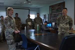 U.S. Air Force Staff Sgt. Alexis Krippel, left, briefs Col. Jun S. Oh on her role as a military working dog handler at Joint Base Andrews, Maryland, on June 16, 2025. Oh visited to recognize Krippel as the June “Winnin’ Like a Griffin” honoree.