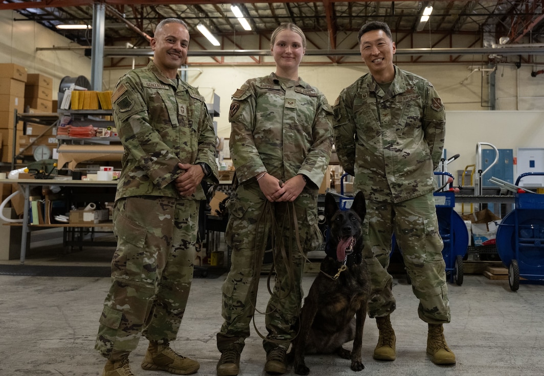 U.S. Air Force Chief Master Sgt. Alejandro Gonzalez, Staff Sgt. Alexis Krippel, and Col. Jun S. Oh stand side by side, smiling for a group photo at Joint Base Andrews, Maryland, on June 16, 2025. Krippel was recognized for her work as a military working dog handler during the 316th Wing’s “Winnin’ Like a Griffin” program.
