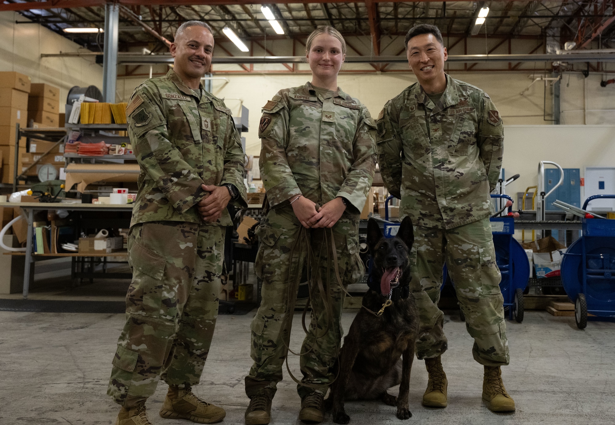 U.S. Air Force Chief Master Sgt. Alejandro Gonzalez, Staff Sgt. Alexis Krippel, and Col. Jun S. Oh stand side by side, smiling for a group photo at Joint Base Andrews, Maryland, on June 16, 2025. Krippel was recognized for her work as a military working dog handler during the 316th Wing’s “Winnin’ Like a Griffin” program.