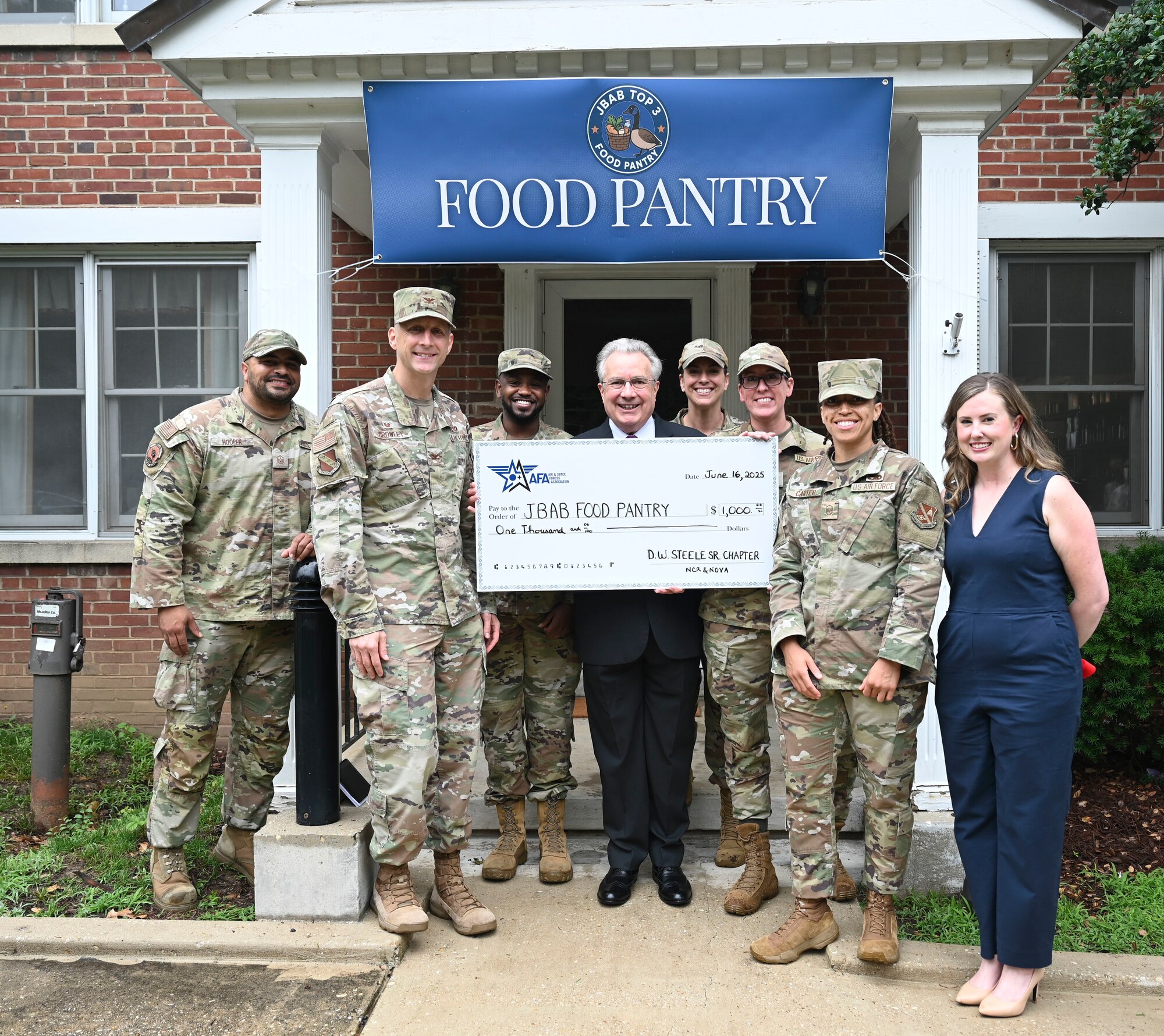Leaders of Joint Base Anacostia-Bolling and the 11th Wing gather for a group photo with partners from the Air and Space Association during the opening of the base’s food pantry at JBAB, Washington, D.C., June 16, 2025.