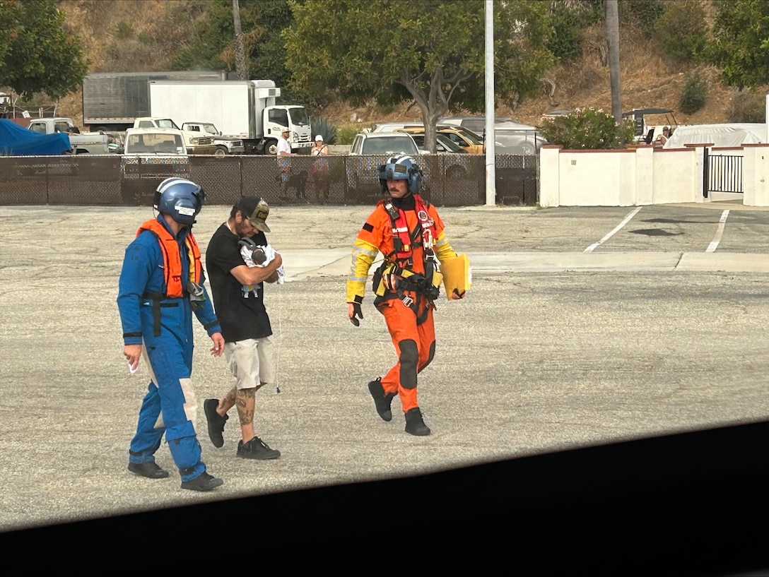 U.S. Coast Guard Air Station Ventura air crew members escort a newborn to the helicopter on Catalina Island, California, June 30, 2025. The Coast Guard completed the medevac of a mother and her newborn baby from the island to a shoreside medical facility. (U.S. Coast Guard Courtesy Photo)