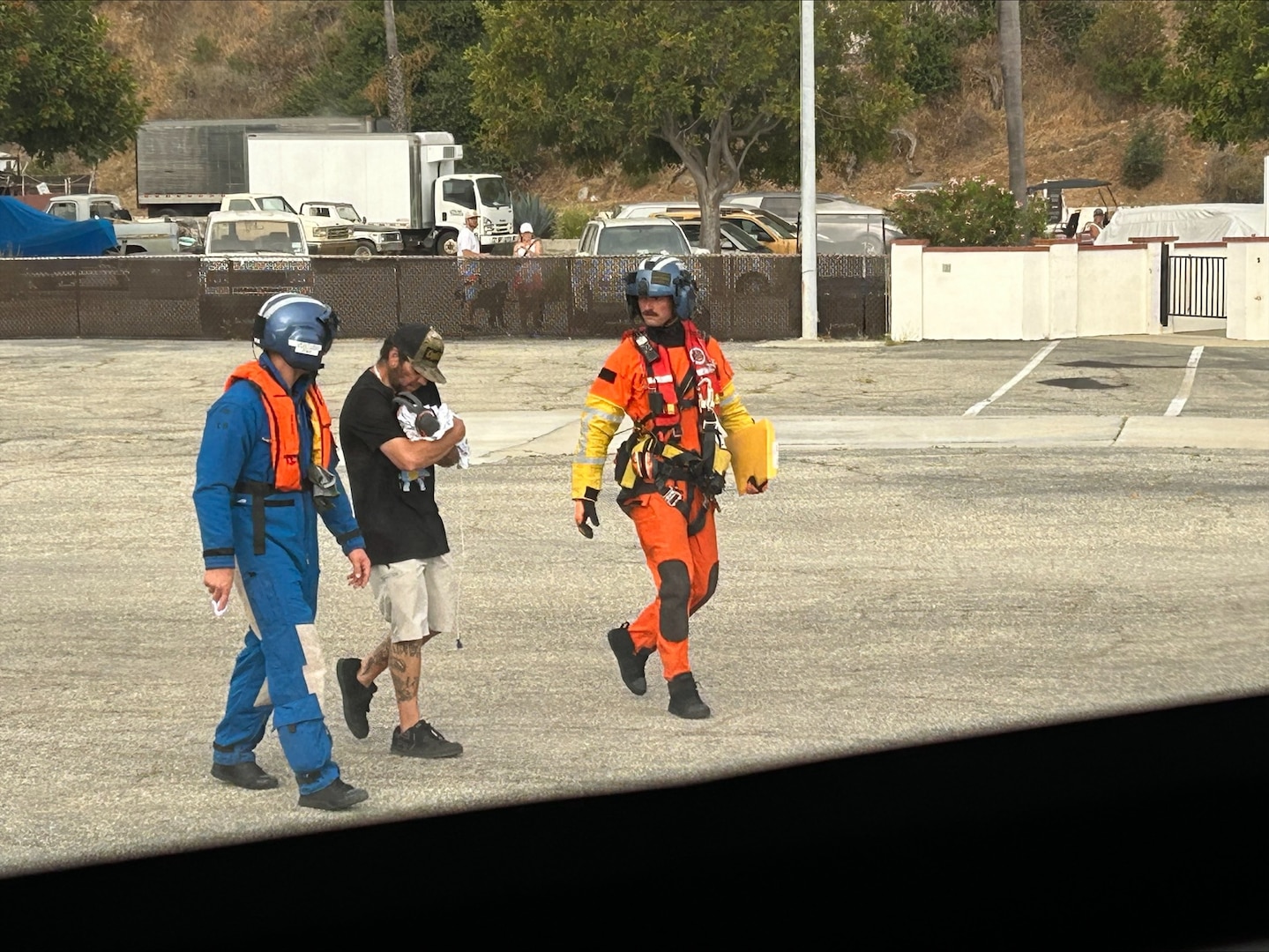 U.S. Coast Guard Air Station Ventura air crew members escort a newborn to the helicopter on Catalina Island, California, June 30, 2025. The Coast Guard completed the medevac of a mother and her newborn baby from the island to a shoreside medical facility. (U.S. Coast Guard Courtesy Photo)