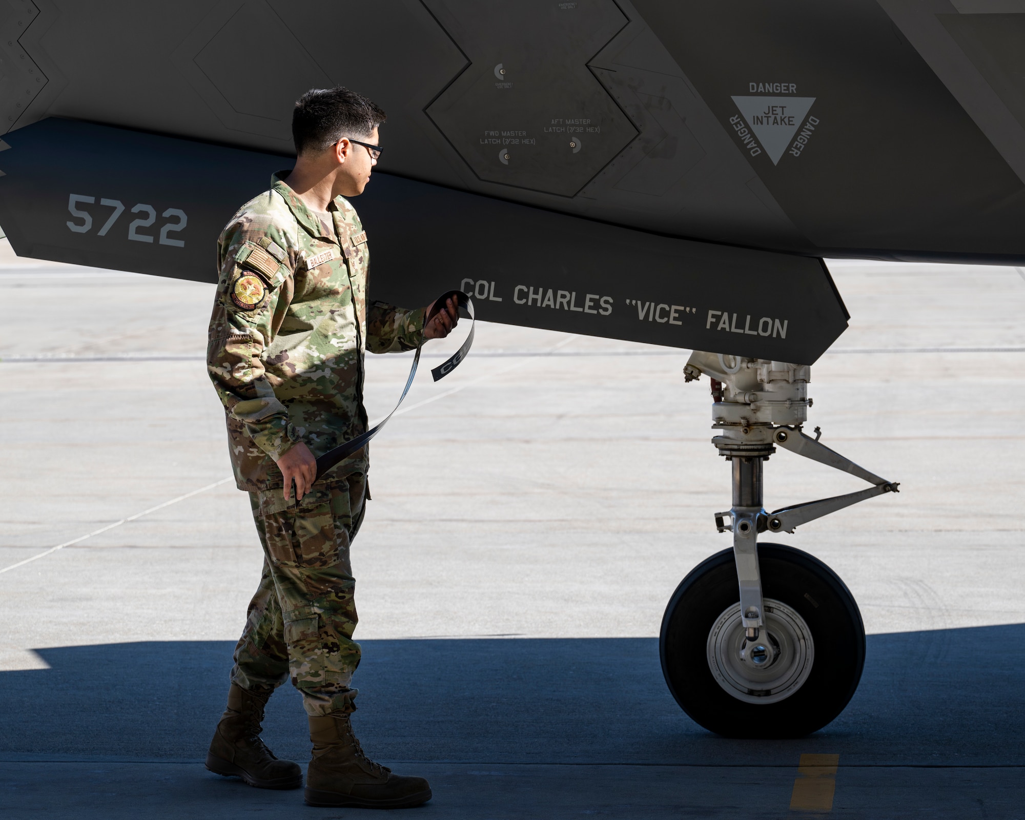 A photo of an Airman revealing a name stenciled on an F-35