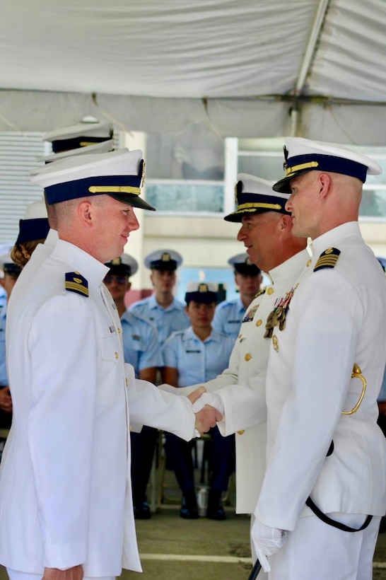 Capt. Robert Kinsey and Capt. Craig Allen shake hands with U.S. Coast Guard Cutter Kimball’s (WMSL 756) crew during the Kimball’s change of command ceremony in Honolulu, June 27, 2025.  Allen relieved Kinsey as Kimball’s commanding officer during the ceremony which was presided over by Vice Adm. Andrew Tiongson, commander of U.S. Coast Guard Pacific Area. U.S. Coast Guard photo by Ensign Sean Dreher.