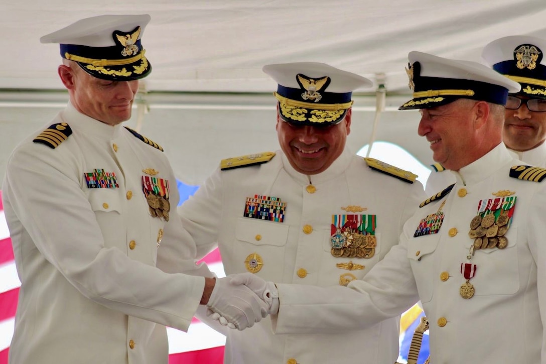 Capt. Robert Kinsey (left) shakes hands with Capt. Craig Allen (right) during the U.S. Coast Guard Cutter Kimball’s (WMSL 756) change of command ceremony in Honolulu, June 27, 2025.  Allen relieved Kinsey as Kimball’s commanding officer during the ceremony presided over by Vice Adm. Andrew Tiongson, commander of U.S. Coast Guard Pacific Area. U.S. Coast Guard photo by Ensign Sean Dreher.