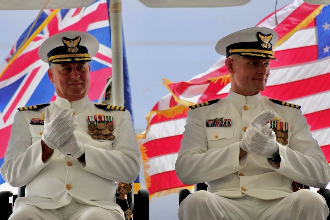 Capt. Robert Kinsey (left) sits on stage with Capt. Craig Allen (right) during the U.S. Coast Guard Cutter Kimball’s (WMSL 756) change of command ceremony in Honolulu, June 27, 2025.  Allen relieved Kinsey as Kimball’s commanding officer during the ceremony presided over by Vice Adm. Andrew Tiongson, commander of U.S. Coast Guard Pacific Area. U.S. Coast Guard photo by Ensign Sean Dreher.