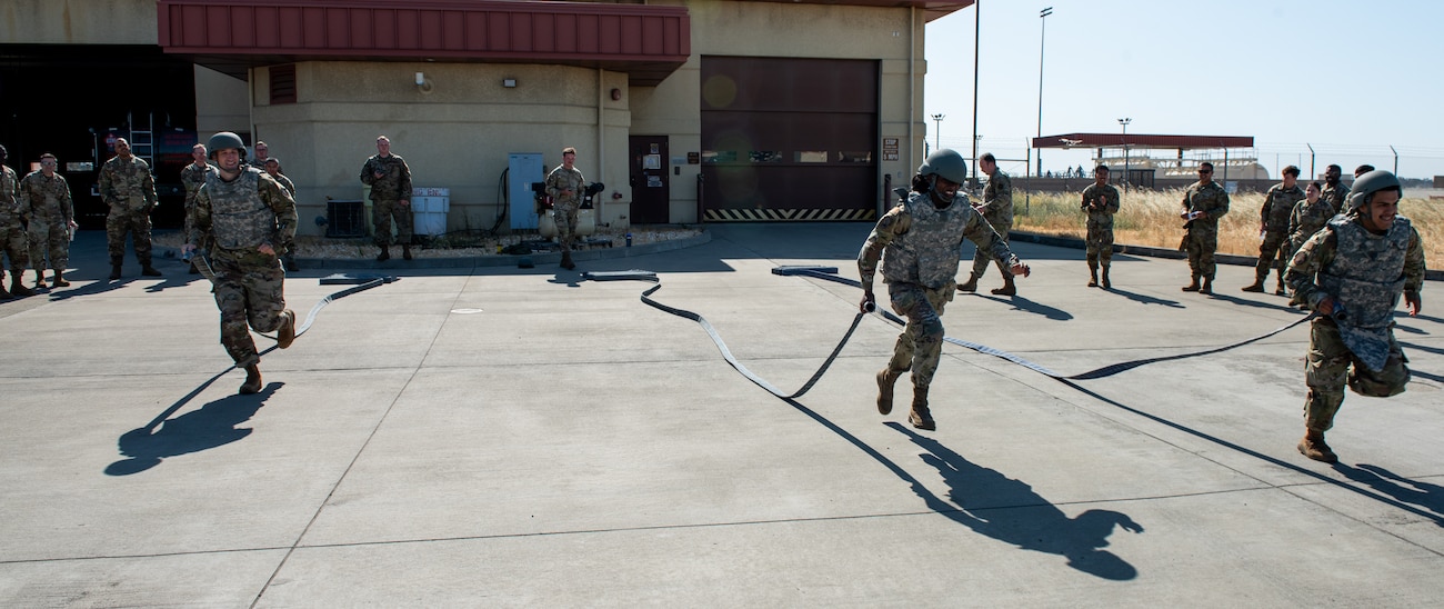 Airmen run with hoses