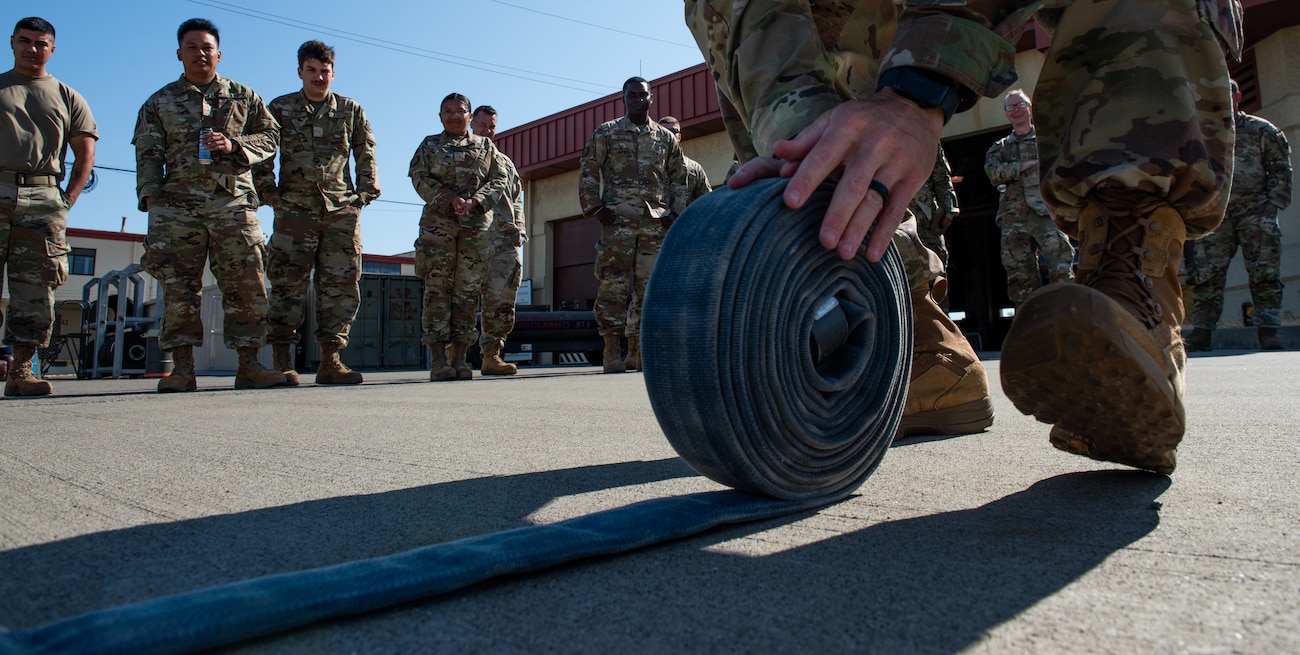 Airman rolls a hose