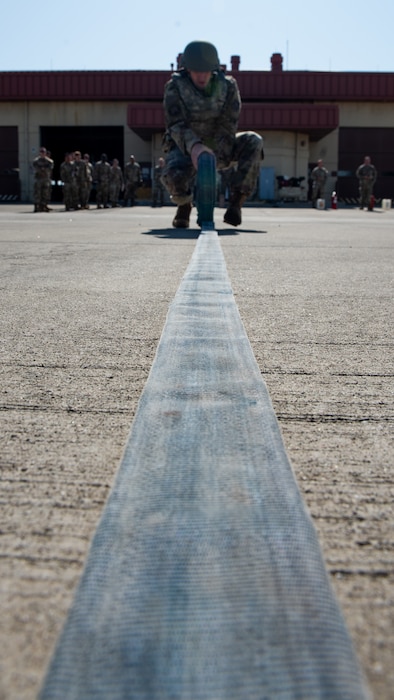 Airman rolls a hose