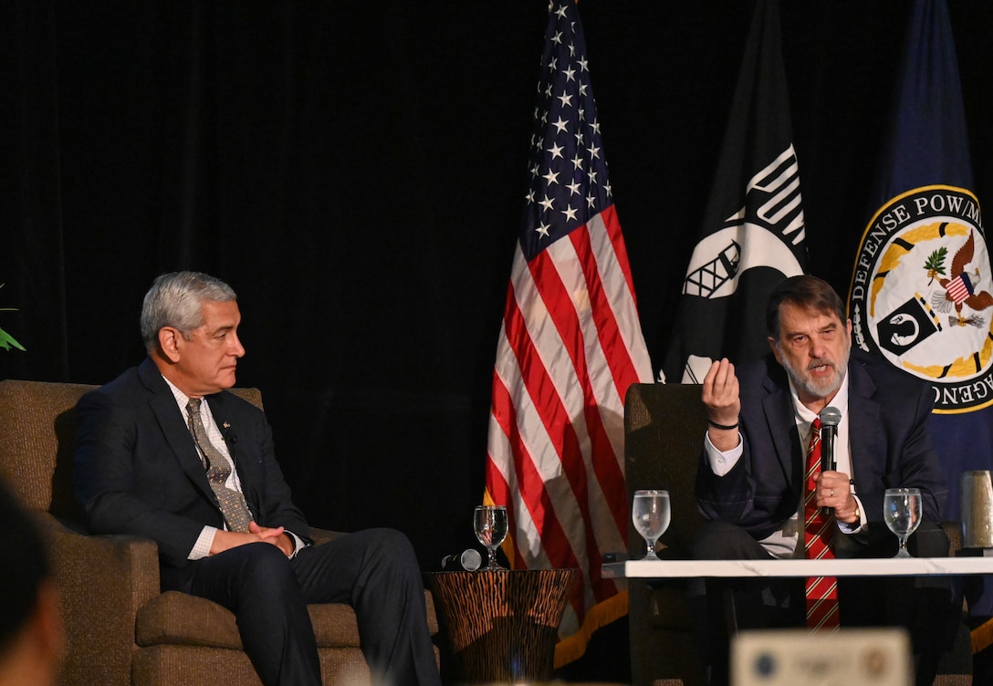 Kelly McKeague, Defense POW/MIA Accounting Agency director, left, and Dr. Tom Holland, research professor and director of the Forensic Institute for Research and Education at Middle Tennessee State University, right, give a brief at the Vietnam War Annual Government Briefing, Omaha, Nebraska, June 26, 2025.