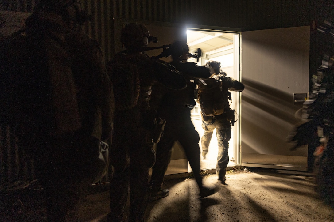 U.S. Marines with Force Reconnaissance Platoon, Maritime Raid Force, 31st Marine Expeditionary Unit, clear a building during a limited scale raid exercise at Sam Hill Airfield, Queensland, Australia, June 21, 2025. Following a ship-to-shore insert, the Marines conducted the limited scale raid night exercise in a contaminated environment to demonstrate operational proficiency in complex conditions and enhance readiness for chemical, biological, radiological, and nuclear threat scenarios. The 31st MEU is operating aboard ships of the USS America Amphibious Ready Group in the 7th Fleet area of operations, the U.S. Navy’s largest forward-deployed numbered fleet, and routinely interacts and operates with allies and partners in preserving a free and open Indo-Pacific region. (U.S. Marine Corps photo by Cpl. Alora Finigan)