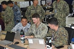 U.S. Marine Corps Maj. David Miller (right), the current operations officer with Marine Rotational Force – Darwin 25.3, conducts planning with his Navy and Malaysian Armed Forces counterparts at the Joint Warfighting Center, Kuantan, Malaysia, June 20, 2025.