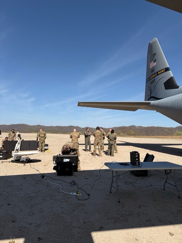 Airmen from the 130th Airlift Wing set up communications and support equipment under the wing of a C-130J Super Hercules during phase one of the Remote Integrated C-130J Omnidomain Operations Program (RICO-OP) at an austere landing strip in Logan County, W.Va., in early 2025. The exercise tested Agile Combat Employment and Mission Ready Airman capabilities in remote environments. (Courtesy photo)