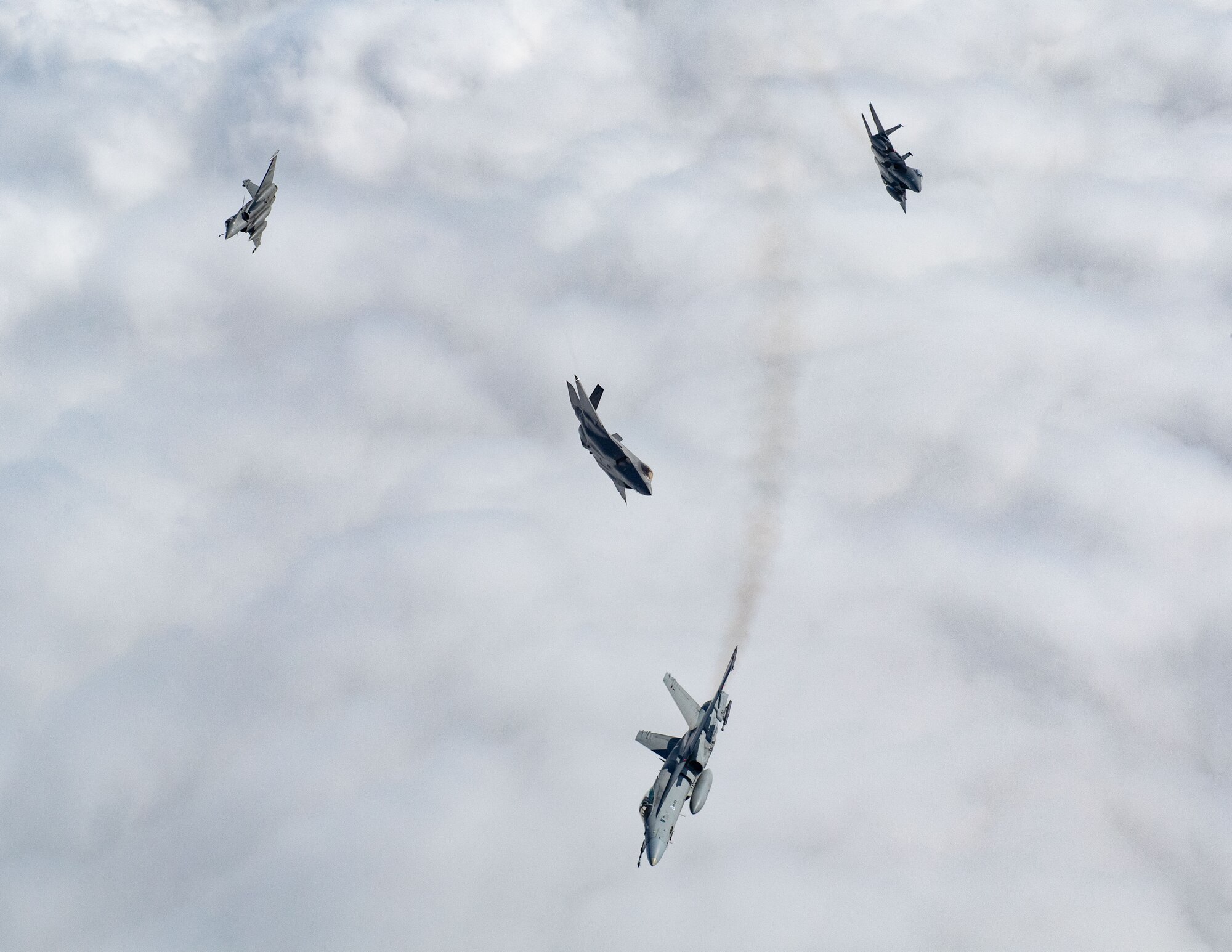 A U.S. F-15E Strike Eagle, U.S. F-35A Lightning II, Finnish F/A-18 Hornet, and French Rafale break away from a formation during exercise Atlantic Trident 25 over Finland, June 20, 2025. Atlantic Trident 25 builds military capability and warfighting capacity between the U.S., U.K., France and Finland to support deterrence and defense of the Euro-Atlantic region, ensuring continued readiness, adaptability and lethality. (U.S. Air National Guard photo by Airman 1st Class Bridget Rossignol)