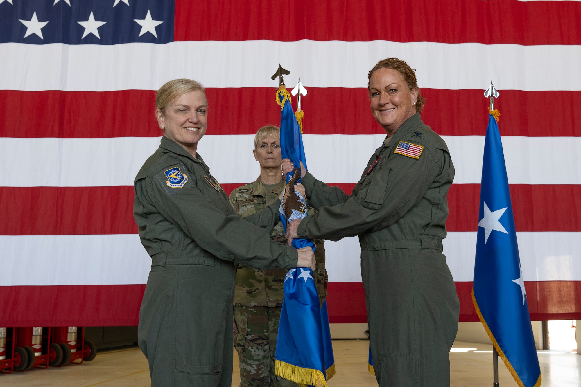 Two woman on stage holding a flag.
